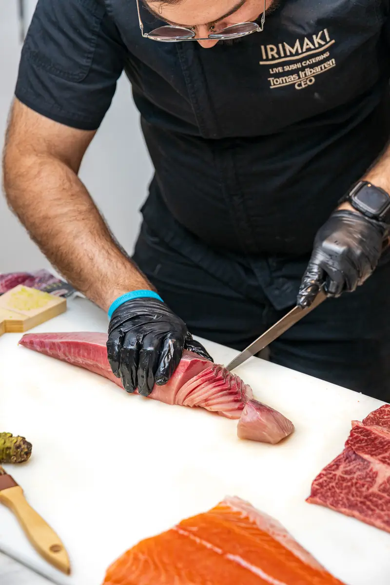 An Irimaki chef slicing fish at a live station